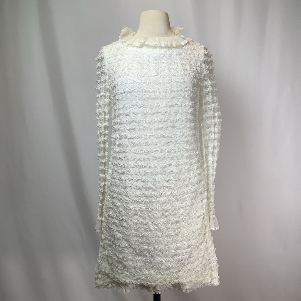 White textured dress on a mannequin against a plain background