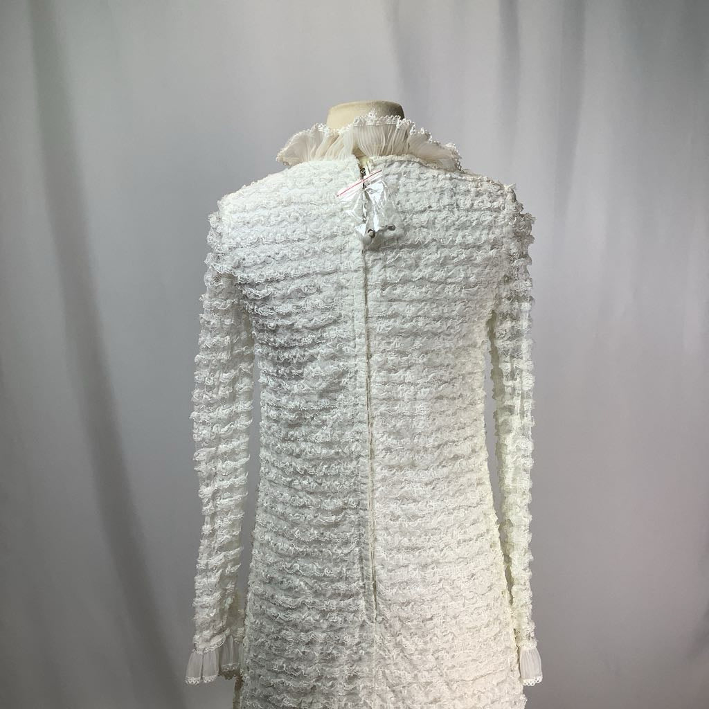 White textured dress on a mannequin against a plain background