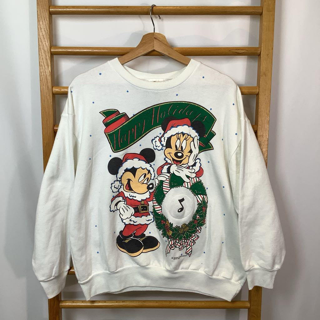 White sweatshirt with Christmas-themed design featuring cartoon characters on a wooden hanger against a white wall.