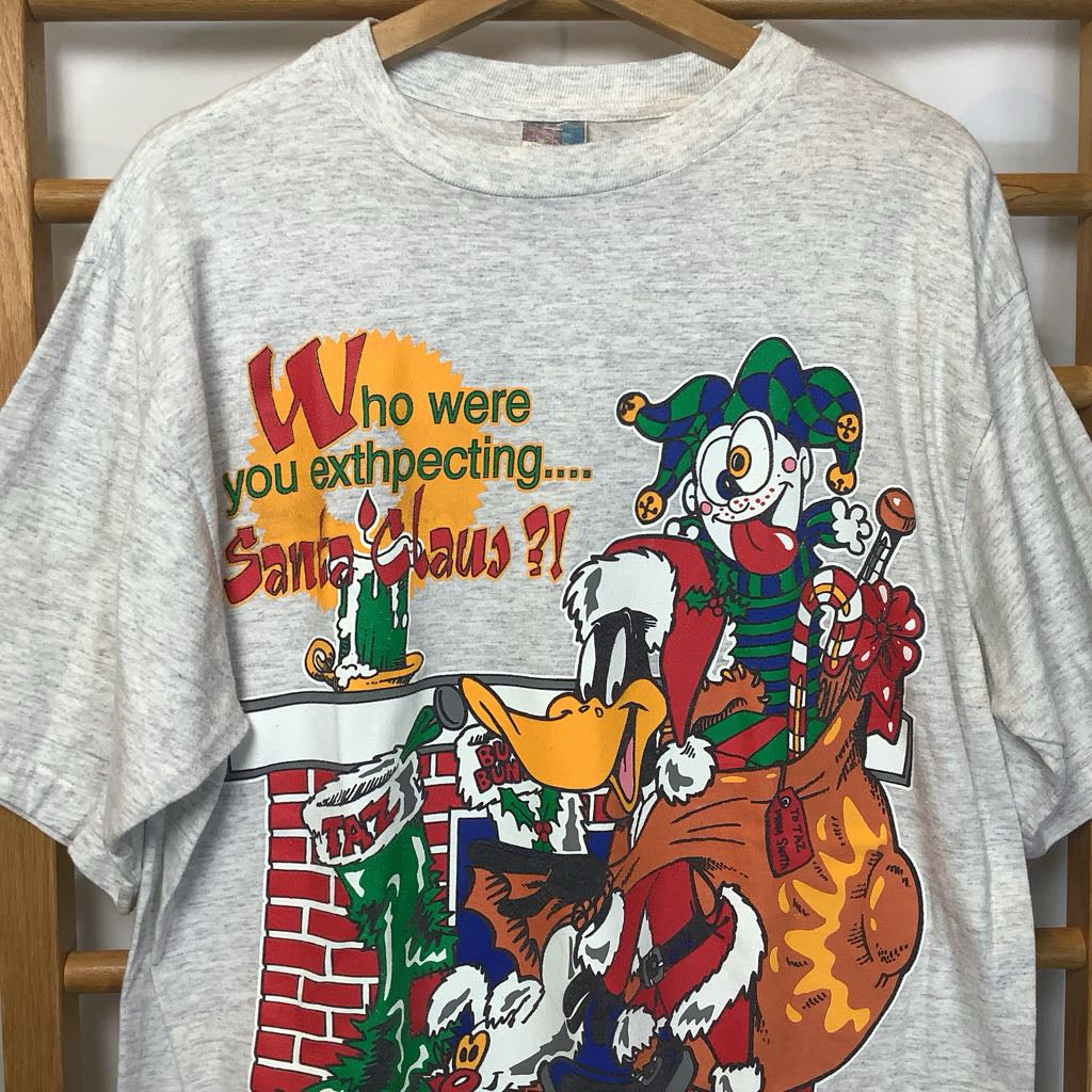 Gray t-shirt with a colorful graphic of a character and text on a wooden rack.