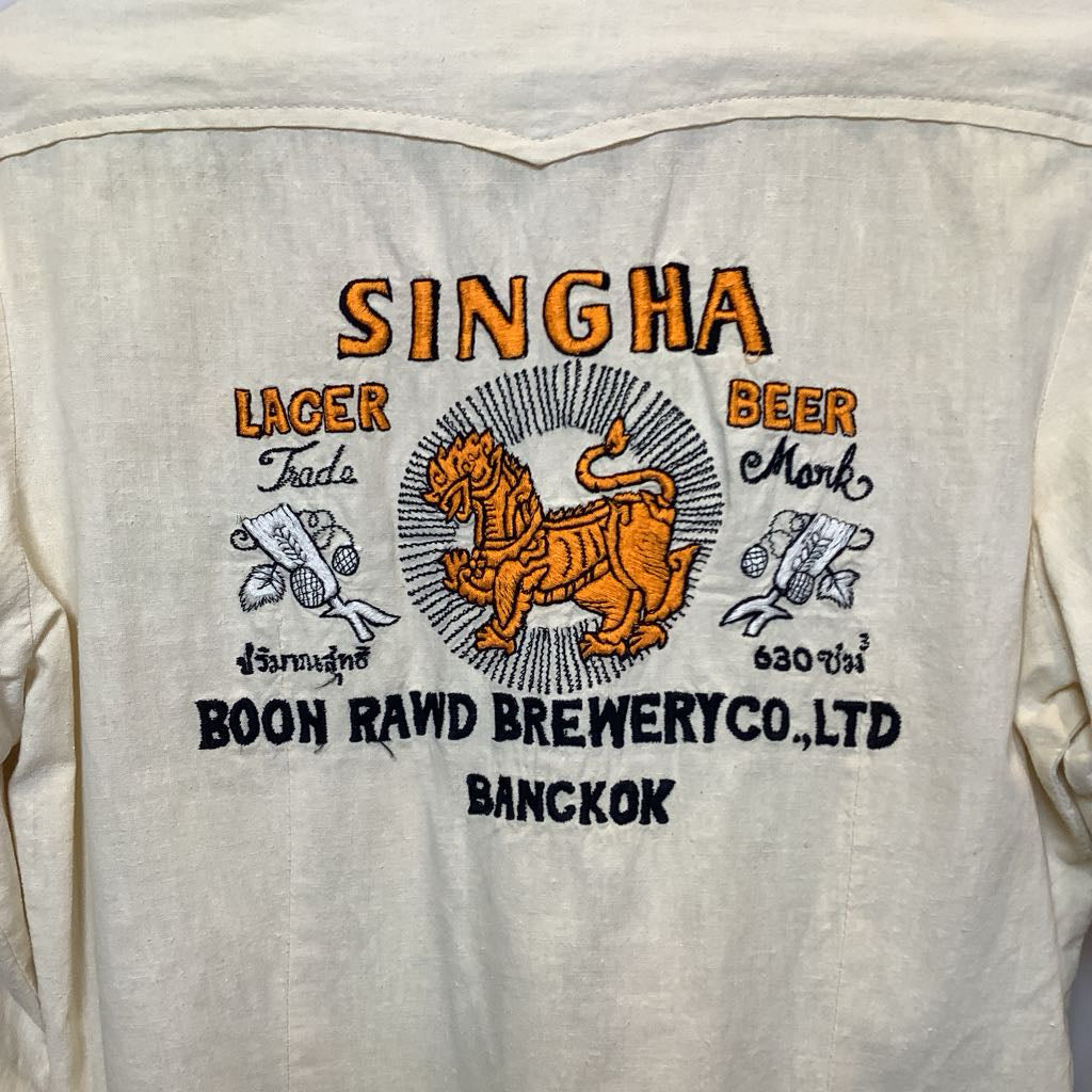 Light-colored shirt with Singha Beer logo and text on the back