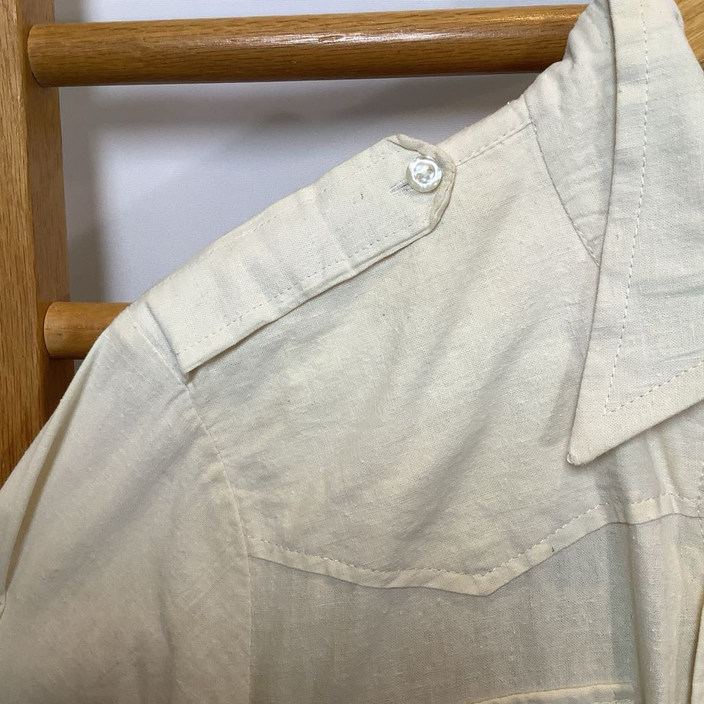 Beige shirt on a wooden hanger against a white background