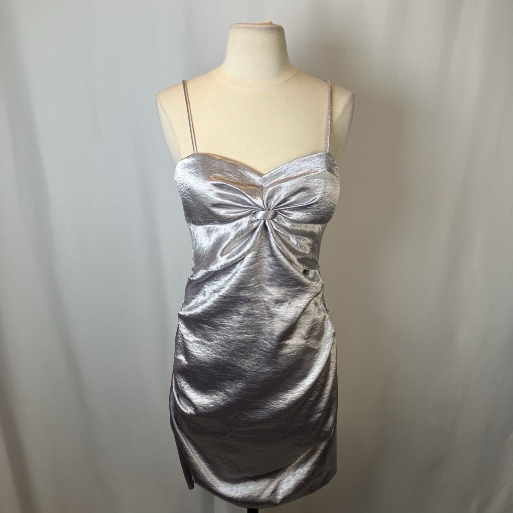 Silver metallic dress on a mannequin against a plain background