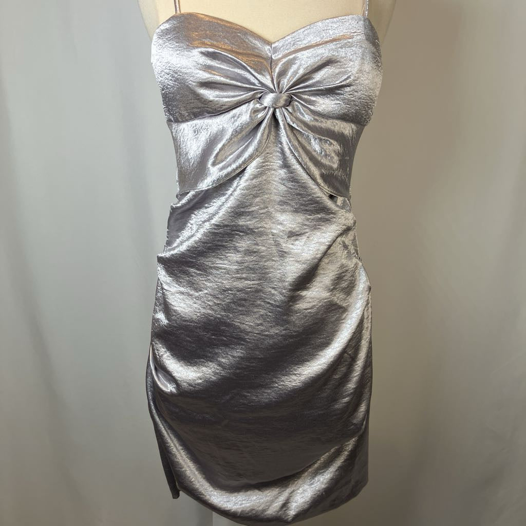 Silver metallic dress on a mannequin against a plain background