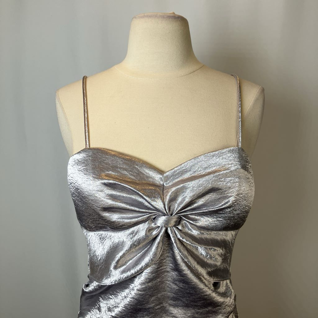 Silver metallic dress on a mannequin against a plain background