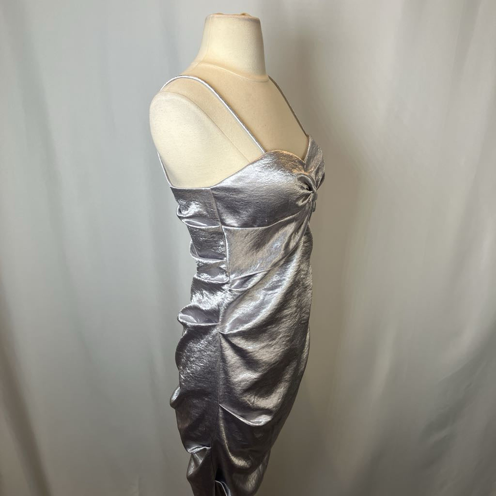 Silver metallic dress on a mannequin against a plain background