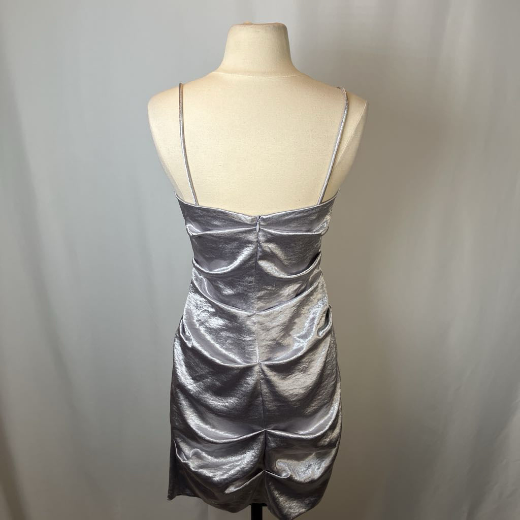 Silver dress on a mannequin against a plain background