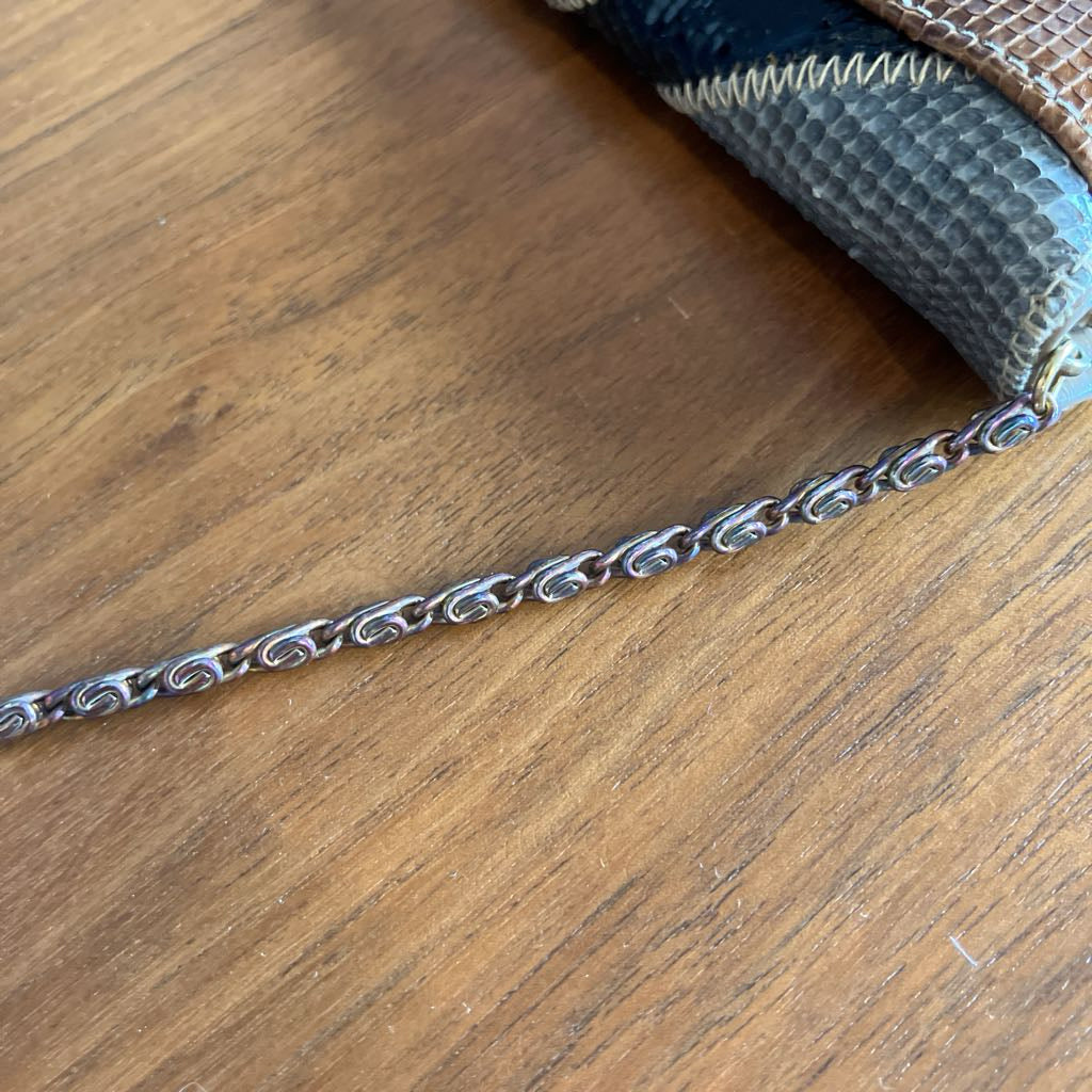 Silver chain on a wooden surface