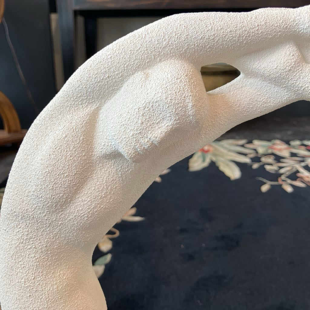 Close-up of a textured white sculpture with a blurred background