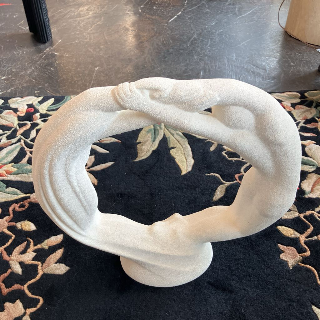 White abstract sculpture on a black textured surface