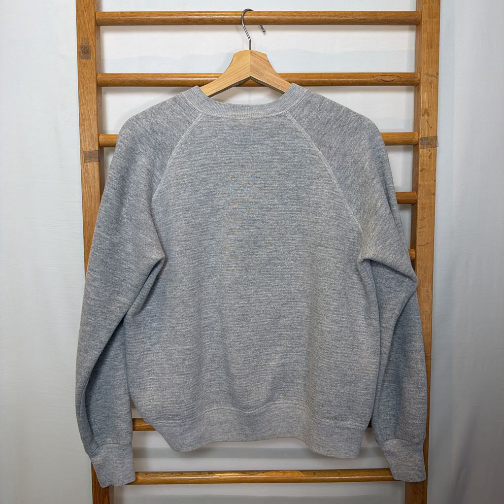 A gray sweatshirt hanging on a wooden rack.