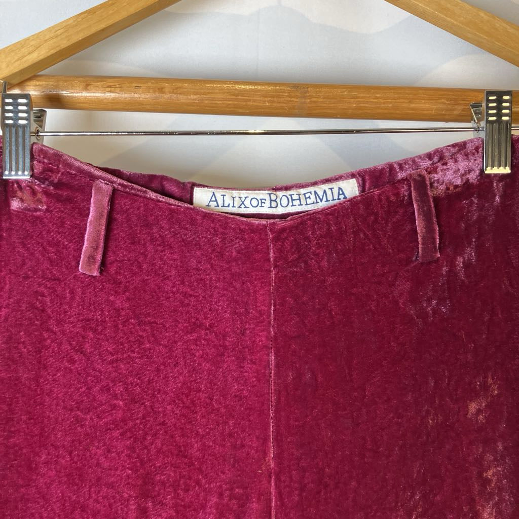 Maroon velvet pants on a hanger with 'Alix of Bohemia' label.