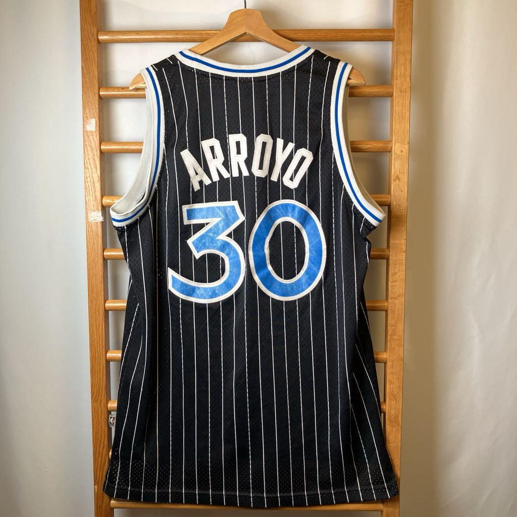 Basketball jersey with 'Arroyo 30' on a wooden rack