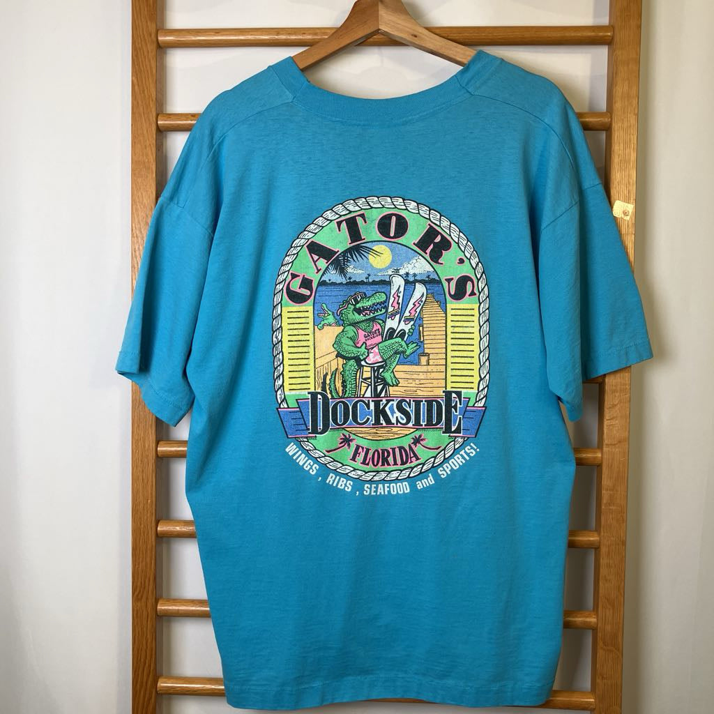 Blue t-shirt with 'Gators Jackson' graphic design on a wooden rack.