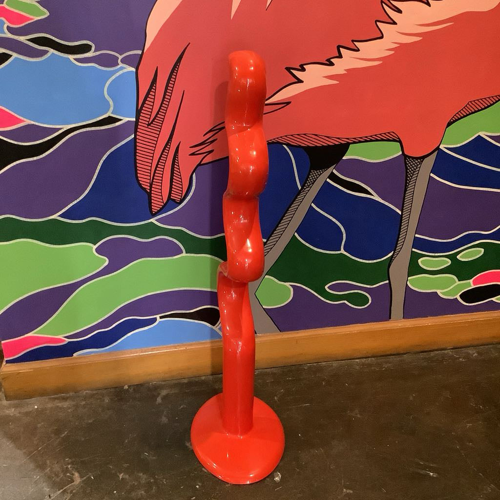 Red sculpture with a colorful mural in the background