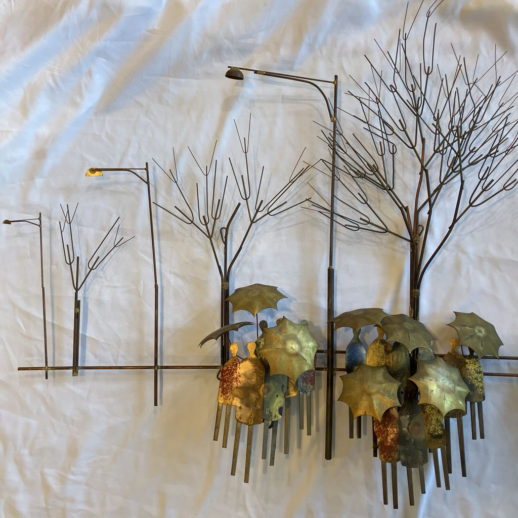 Metal wall art with trees and leaves on a textured white background