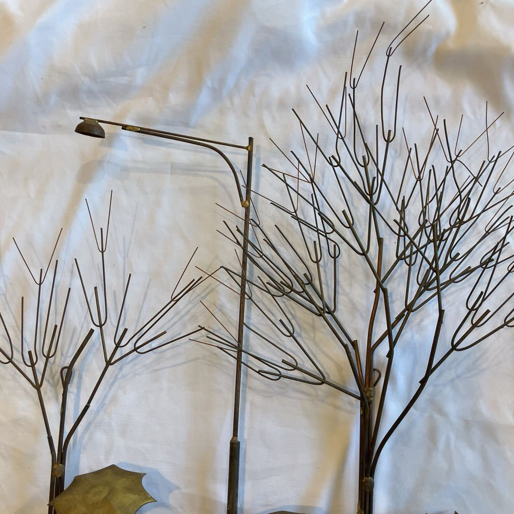 Decorative metal branches on a textured white surface