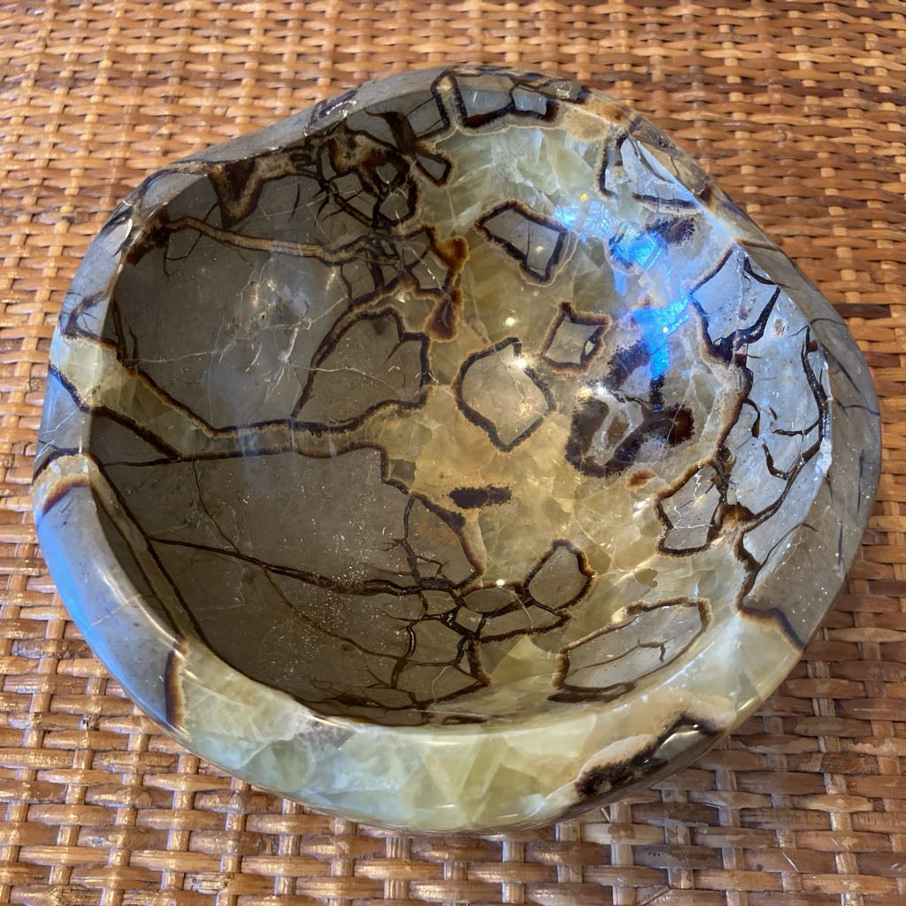 Decorative stone bowl with marbled pattern on a woven surface