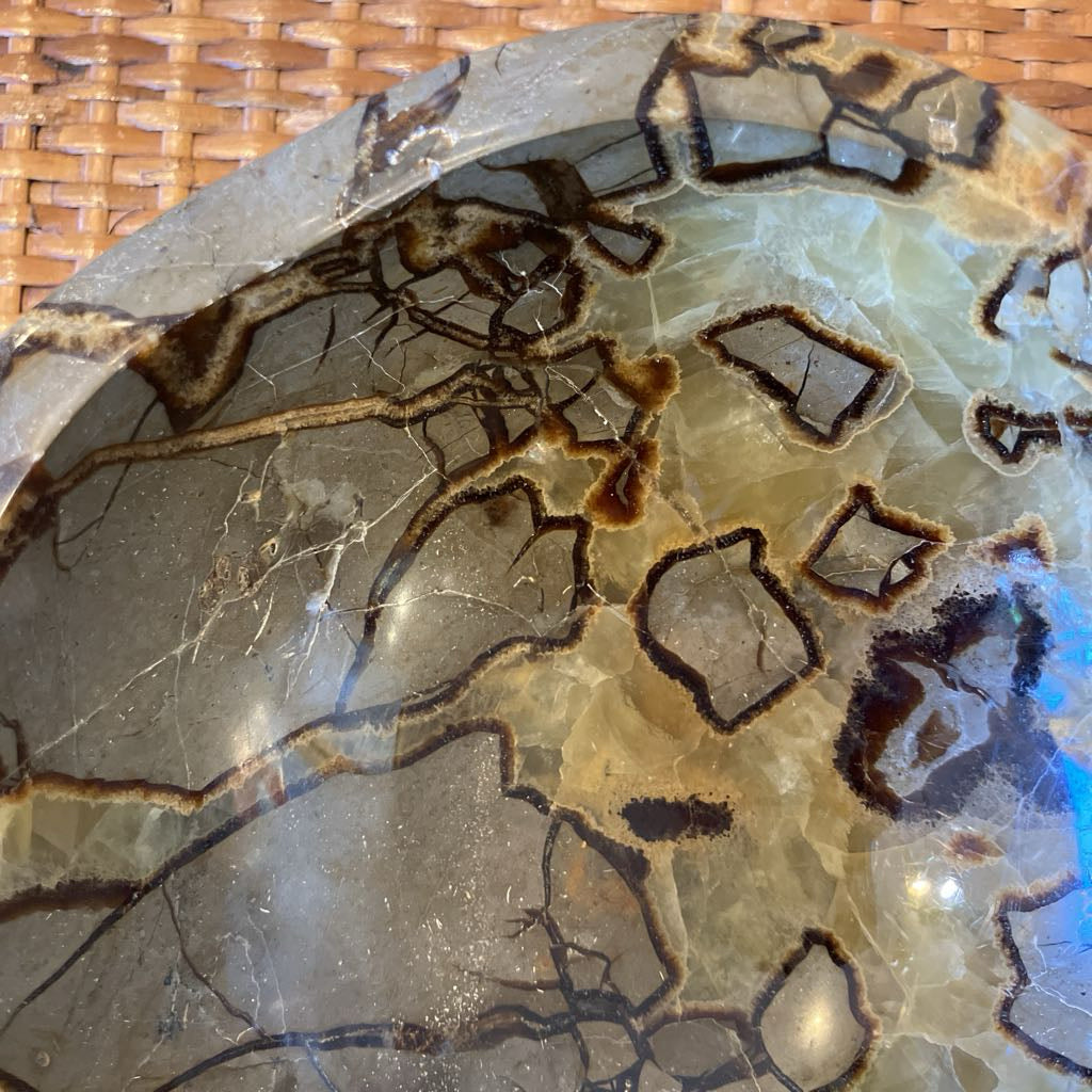 Decorative stone bowl with natural patterns on a woven surface