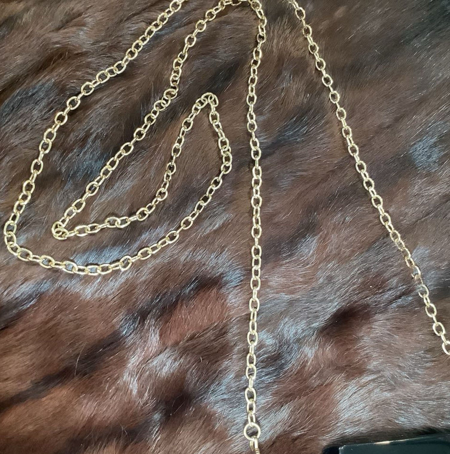 Gold chain necklace on a fur surface