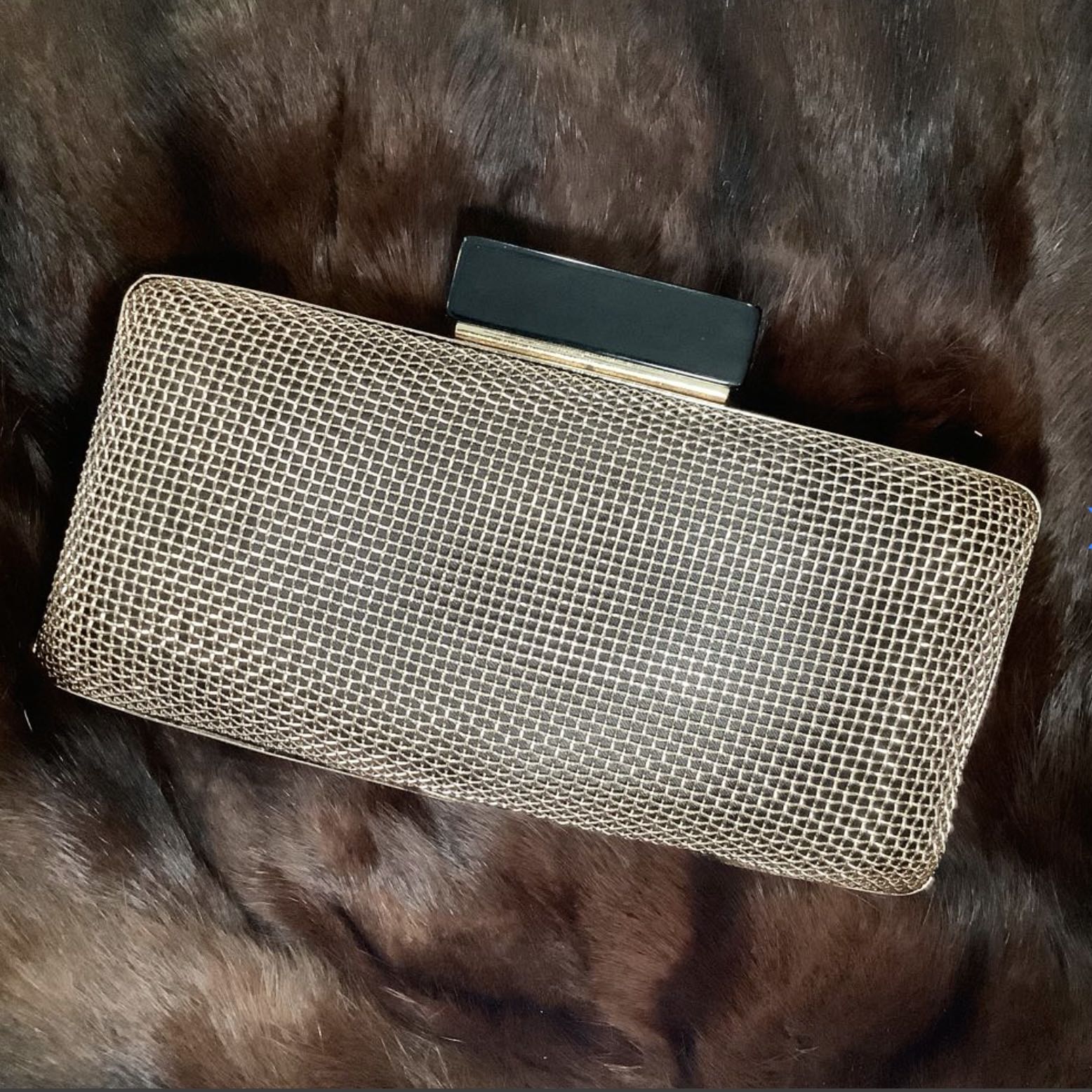 Gold mesh clutch bag on a fur surface