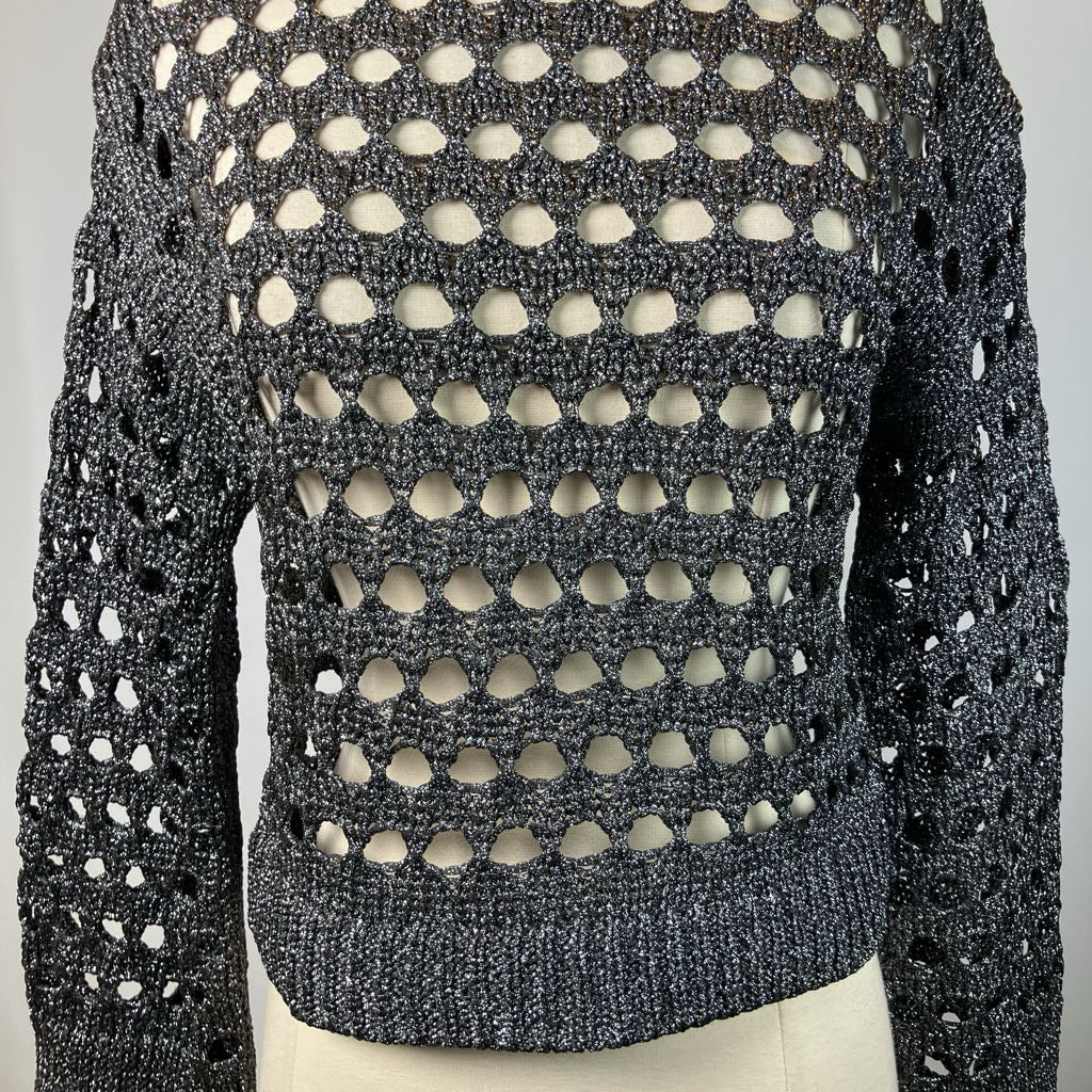 Mannequin wearing a black and white patterned sweater against a gray background