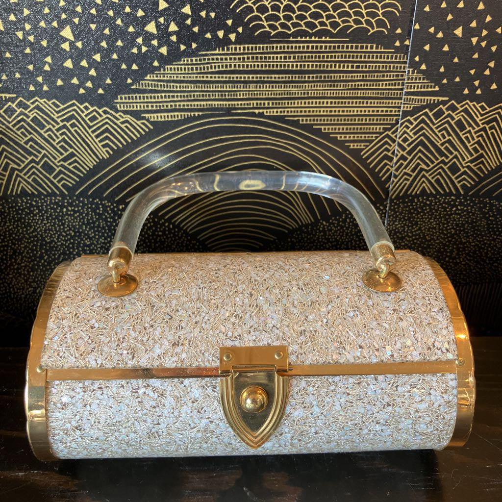 Sparkly handbag with gold accents on a dark background