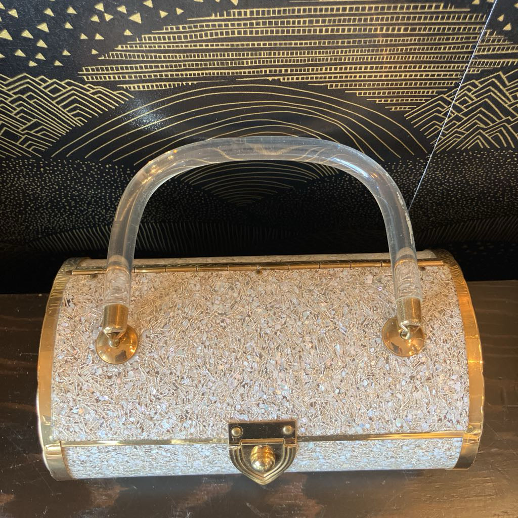 Sparkly handbag with gold accents on a dark textured background