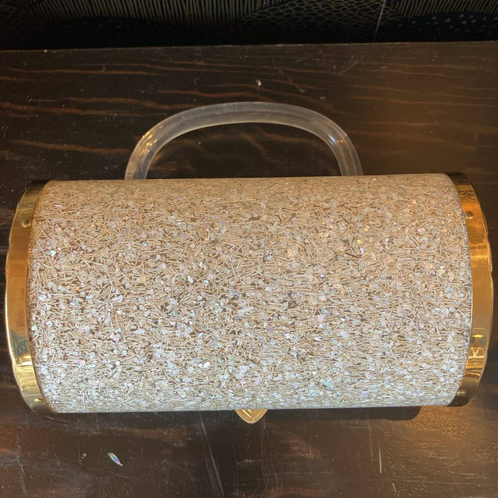 Gold glittery handbag on a dark surface