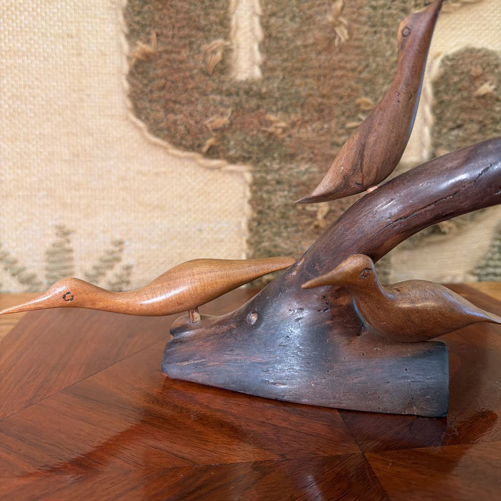 Wooden sculpture of a deer head with antlers on a wooden surface