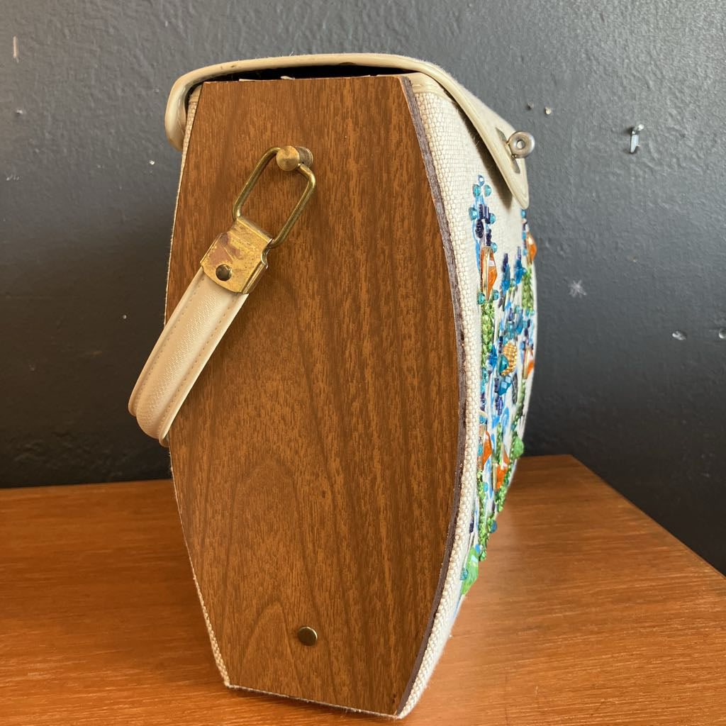 Wooden handbag with a colorful patterned strap on a wooden surface