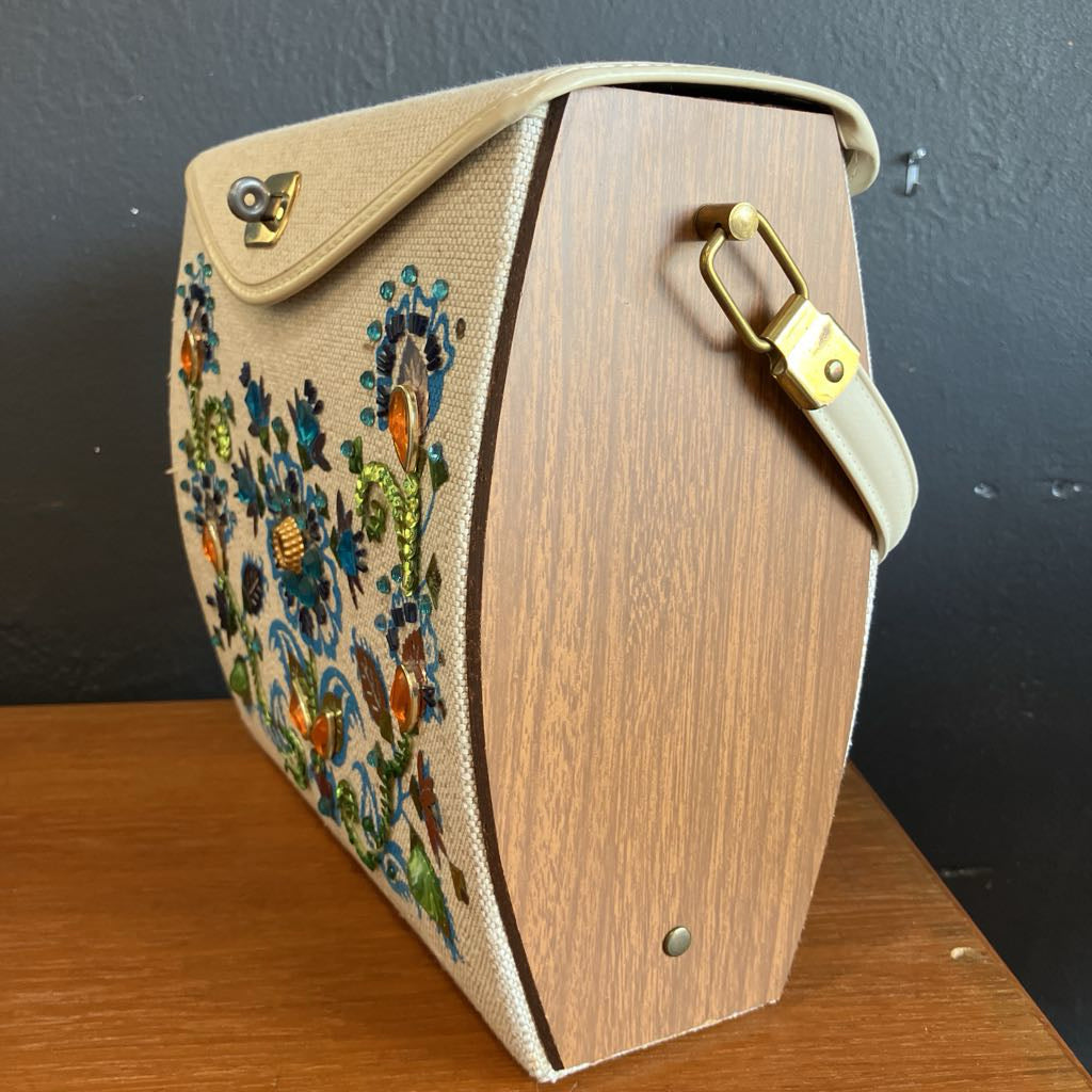 Handbag with wooden side and embroidered floral design on a dark background