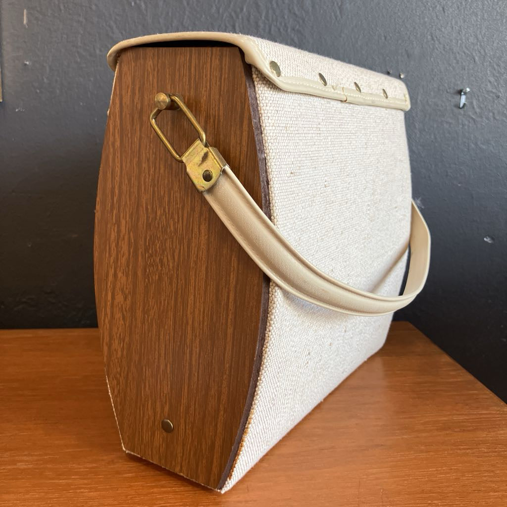 Handbag with wooden side and beige strap on a wooden surface
