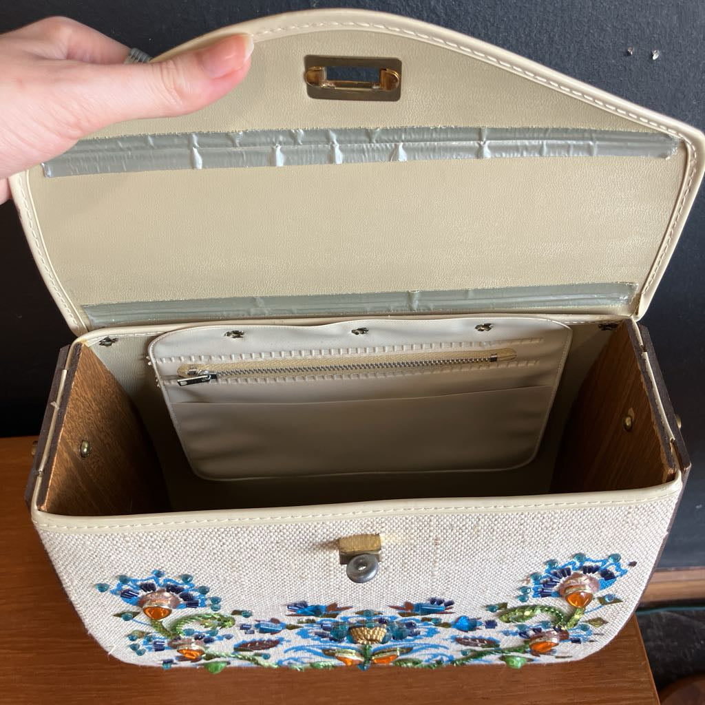 Handbag with floral embroidery on a wooden surface