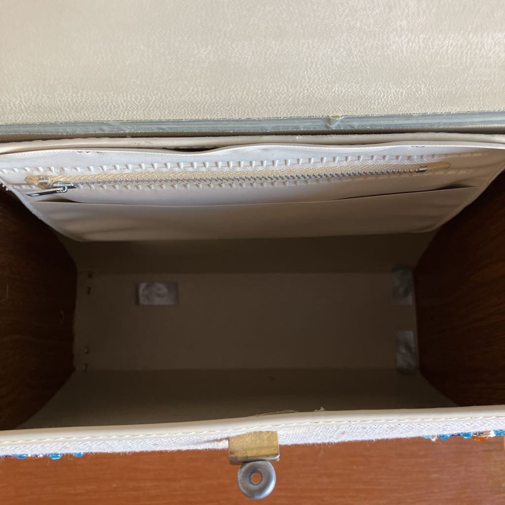 Open beige handbag storage compartment with a white interior