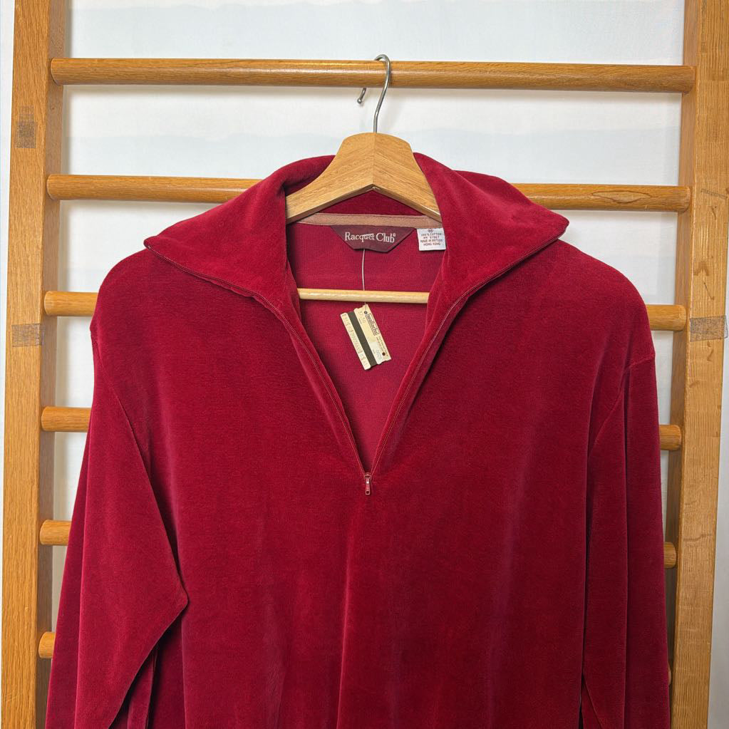 A red velour sweater on a wooden rack.