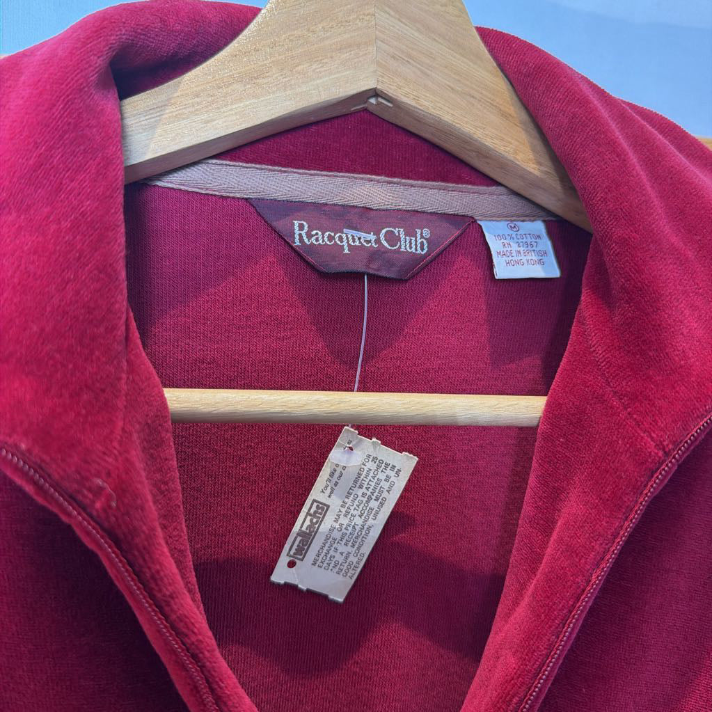 A red velour sweater on a wooden rack.