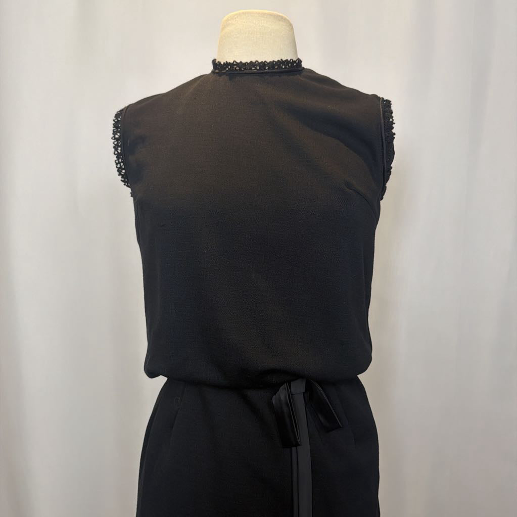 Black sleeveless top with beaded details on a mannequin against a white background