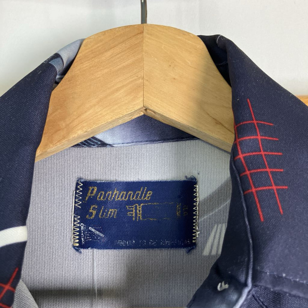 Close-up of a navy blue collared shirt on a wooden hanger, showing the inner neck label that reads 'Parhandle Slim' and a red grid pattern on the collar.