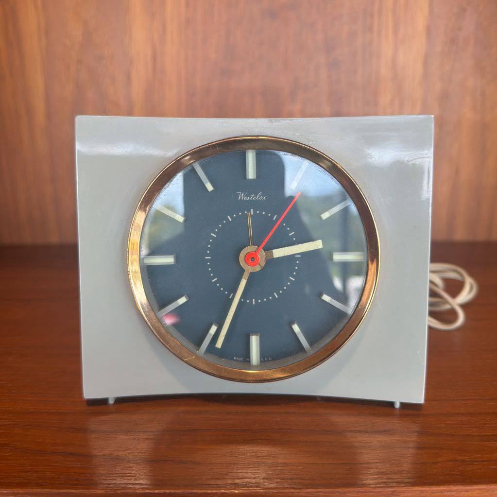 Vintage clock with a blue face and gold casing on a wooden surface