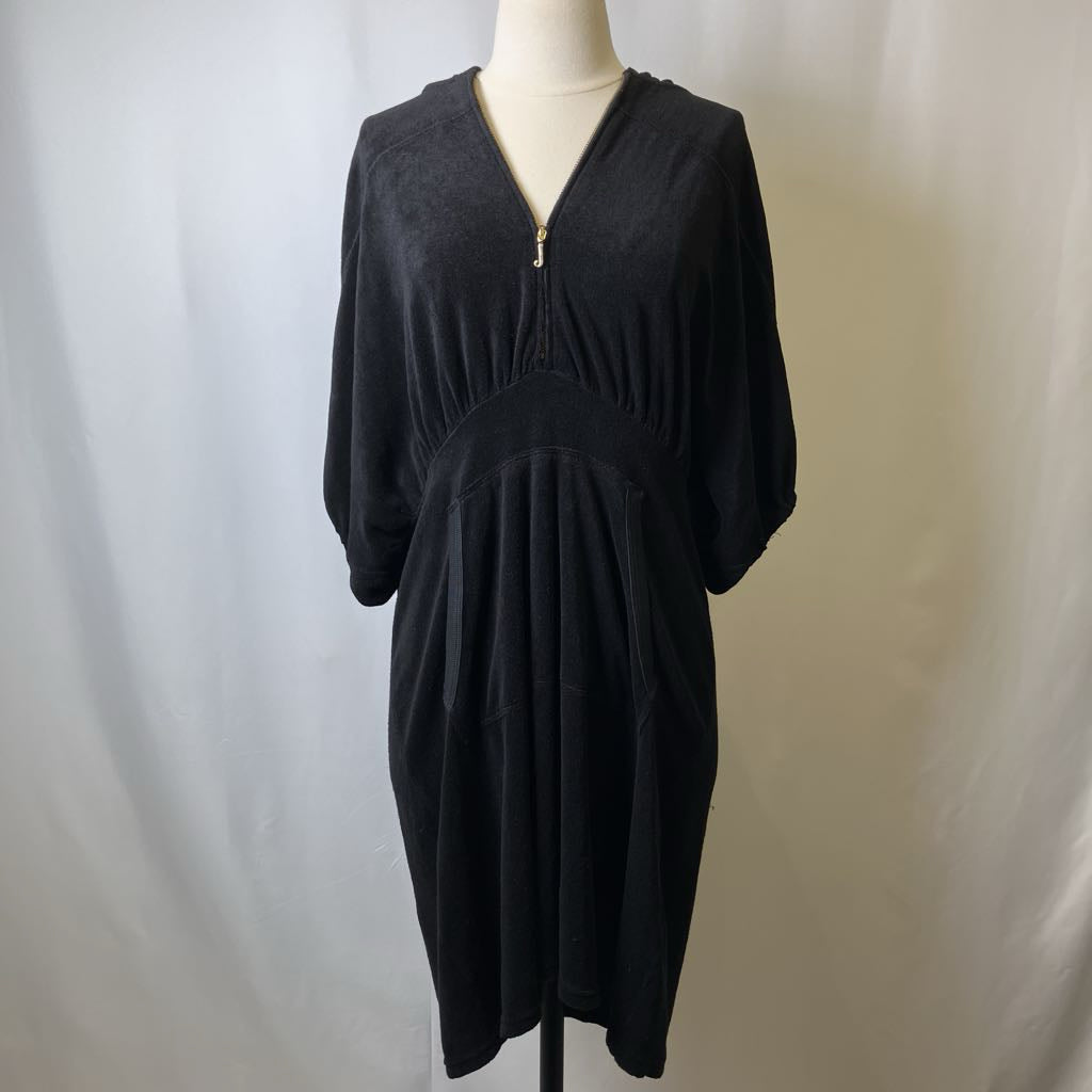 Black dress on a mannequin against a plain background