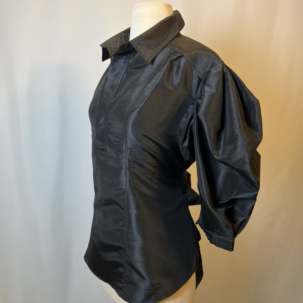 Black shirt on a mannequin against a plain background