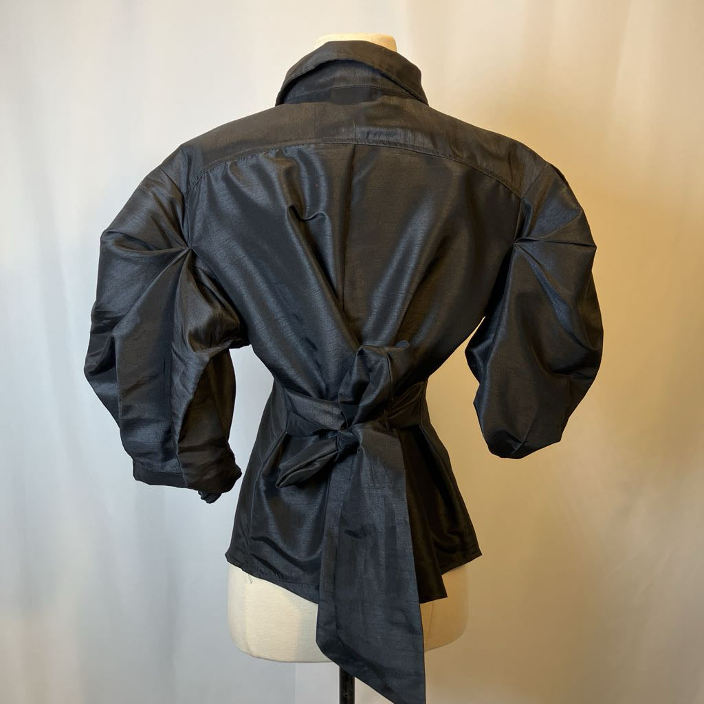 Black blouse on a mannequin against a neutral background