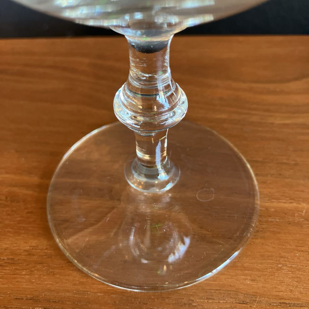 Clear glass coupe stem on a wooden surface