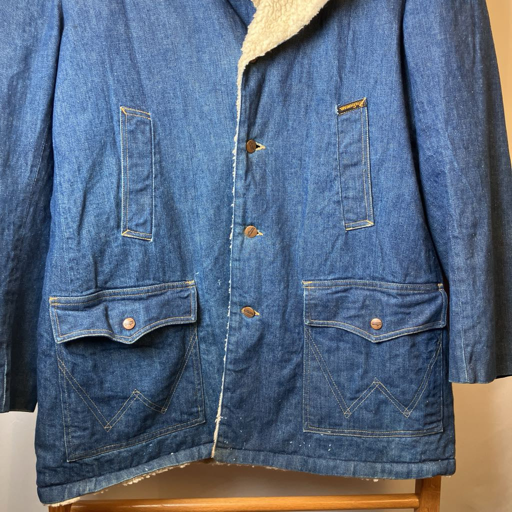 Blue denim jacket with beige lining on a wooden chair