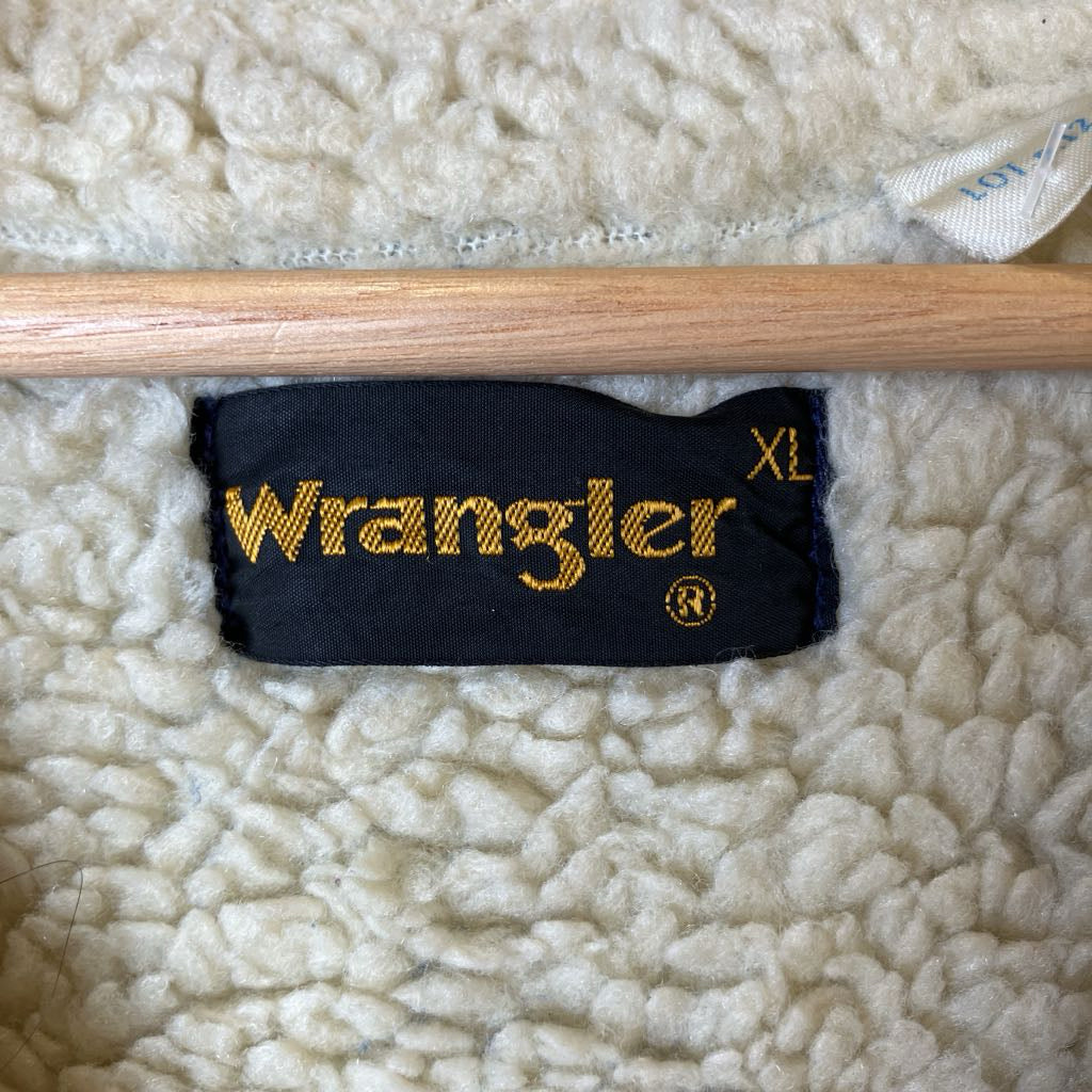 Wooden stick with a Wrangler branded sleeve on a textured surface