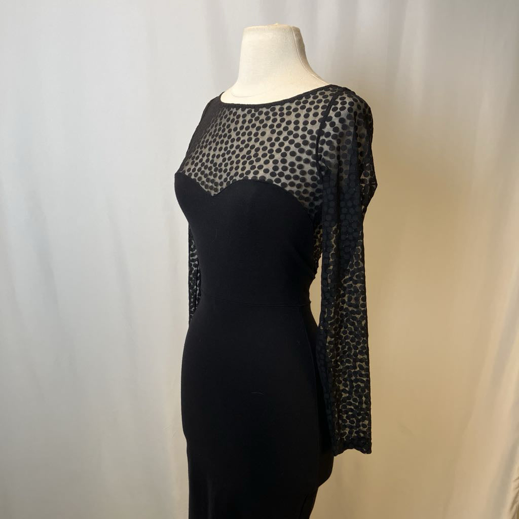 Black dress with sheer leopard print sleeves on a mannequin against a plain background