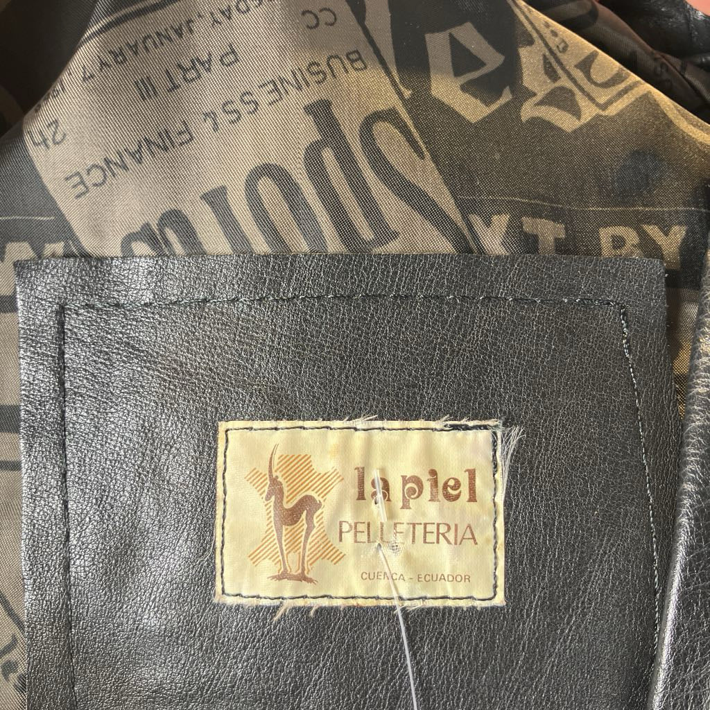 Black leather wallet with a visible brand label on a textured background