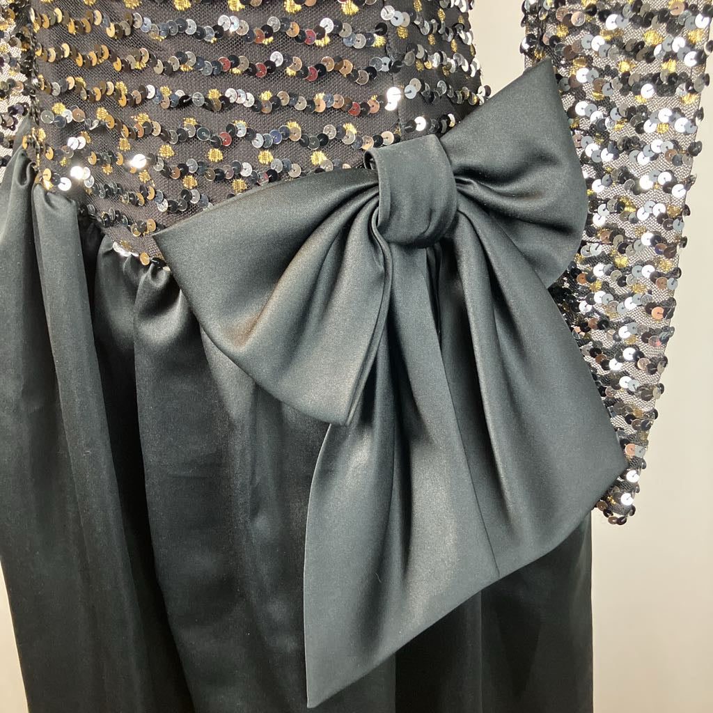 Close-up of a dress with a large bow and sequined details.