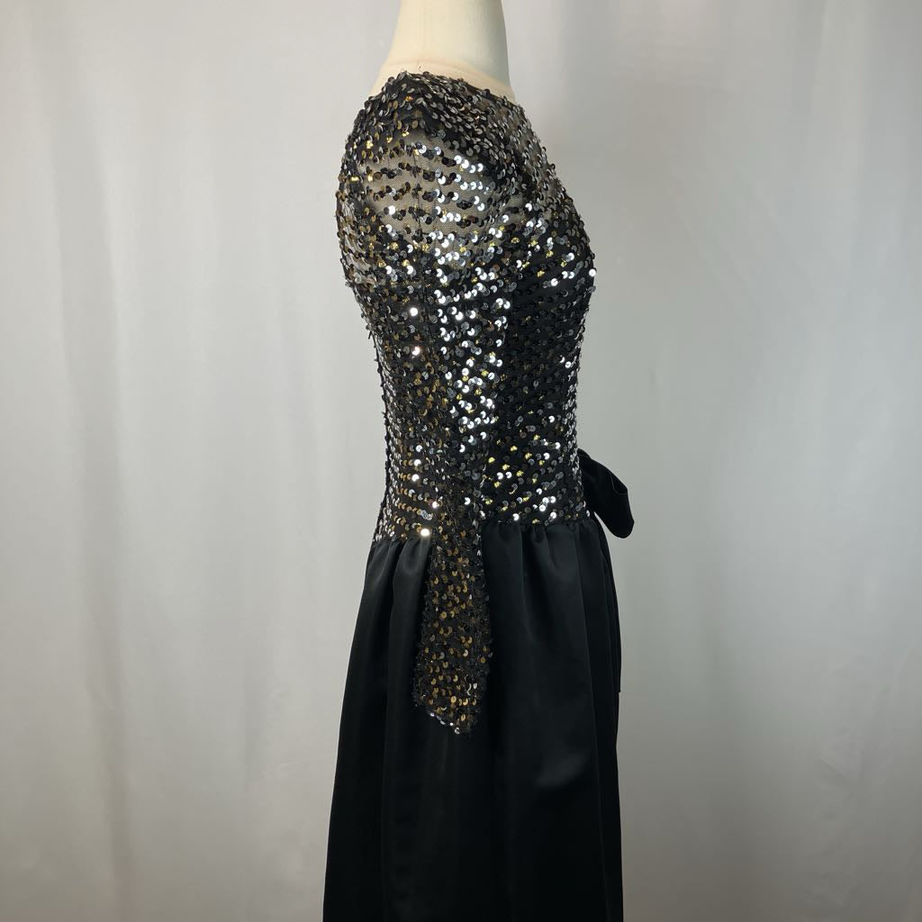 Black evening gown with sequin embellishments on a mannequin against a plain background